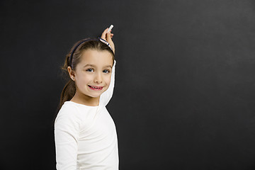 Image showing Girl writing in a blackboard