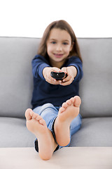 Image showing Girl holding a TV remote