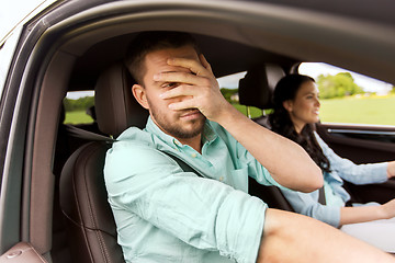 Image showing woman driving car and man covering face with palm