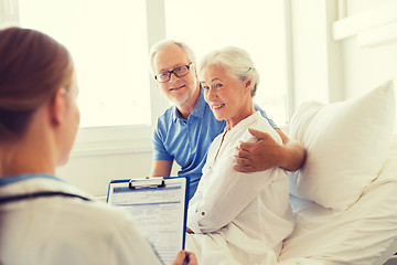 Image showing senior woman and doctor with clipboard at hospital