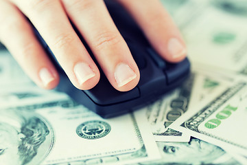 Image showing close up of hand with computer mouse on money