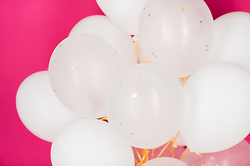 Image showing close up of white helium balloons over pink