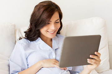 Image showing happy pregnant woman with tablet pc at home