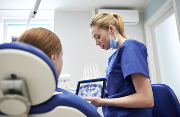 Image showing dentist showing x-ray on tablet pc to patient girl