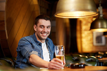 Image showing happy man drinking draft beer at bar or pub