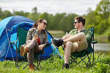 Image showing happy couple drinking beer at campsite tent