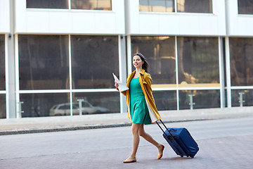 Image showing happy young woman with travel bag and map in city