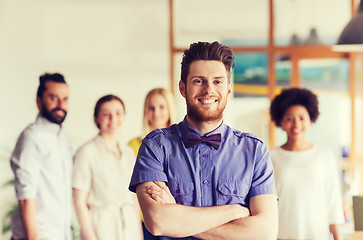 Image showing happy young man over creative team in office