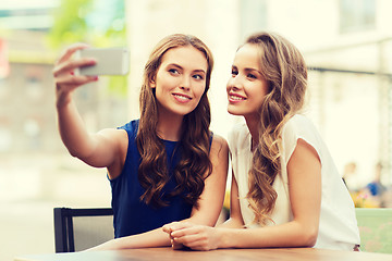 Image showing happy women with smartphone taking selfie at cafe
