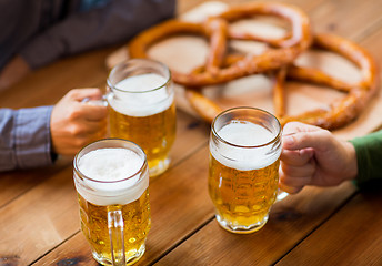 Image showing close up of hands with beer mugs at bar or pub