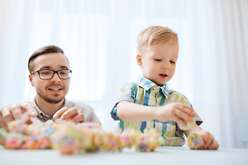 Image showing father and son playing with ball clay at home