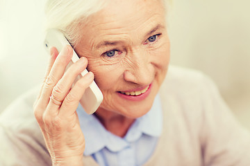 Image showing senior woman with smartphone calling at home