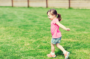 Image showing happy little girl running on green summer field