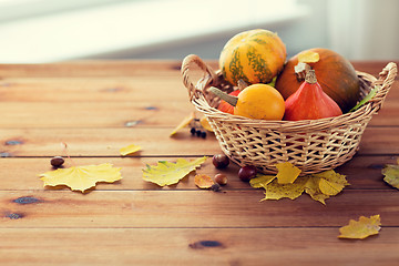 Image showing close up of pumpkins in basket on wooden table