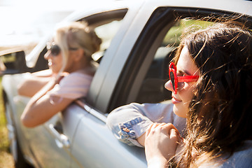 Image showing happy teenage girls or women in car at seaside