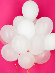 Image showing close up of white helium balloons over pink