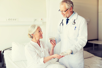 Image showing doctor giving medicine to senior woman at hospital