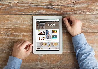 Image showing close up of male hands with tablet pc on table