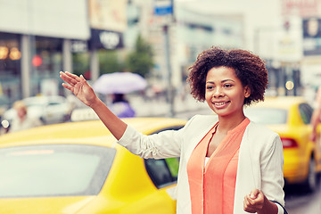 Image showing happy african woman catching taxi