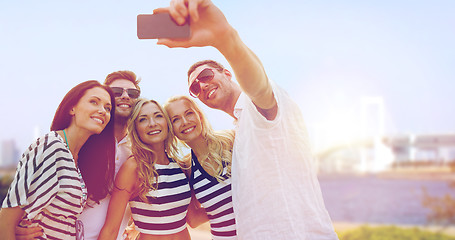 Image showing happy friends taking selfie by smartphone in tokyo