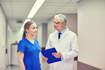 Image showing senior doctor and nurse with tablet pc at hospital