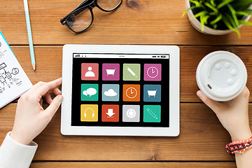 Image showing close up of woman with tablet pc on wooden table