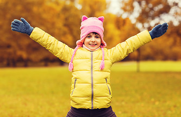 Image showing happy little girl with raised hands outdoors