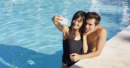 Image showing Handsome couple take photo while standing in pool