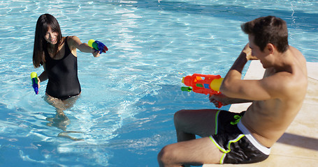 Image showing Adults shooting shooting water guns at each other