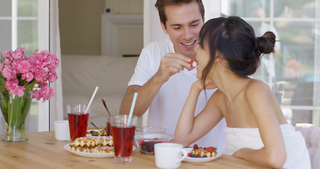 Image showing Man feeding his wife fruit at breakfast