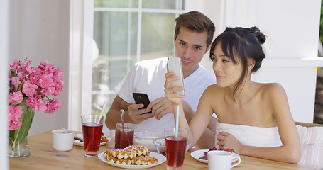 Image showing Woman showing man something on her phone