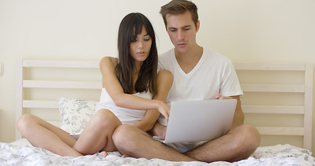 Image showing Woman talking to man using laptop while in bed