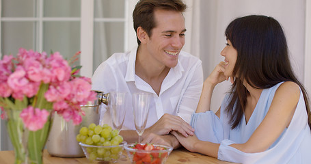 Image showing Cute mixed couple enjoying wine and fruit together