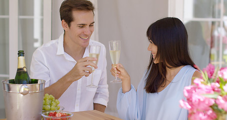 Image showing Young happy adult couple toasting champagne