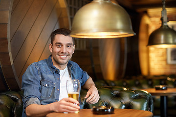 Image showing happy man drinking draft beer at bar or pub