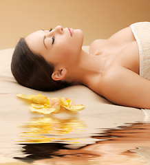 Image showing woman in spa salon lying on the massage desk