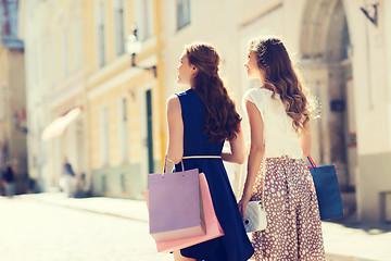 Image showing happy women with shopping bags walking in city 