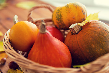 Image showing close up of pumpkins in basket on wooden table