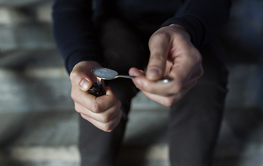 Image showing close up of addict preparing crack cocaine drug