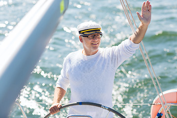 Image showing senior man at helm on boat or yacht sailing in sea