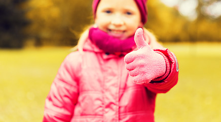 Image showing happy girl showing thumbs up outdoors