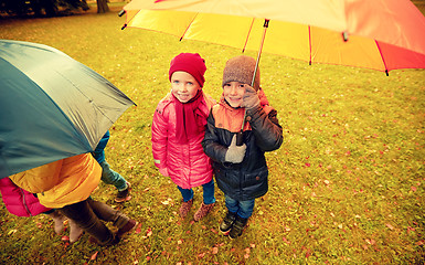 Image showing happy children with umbrella in autumn park