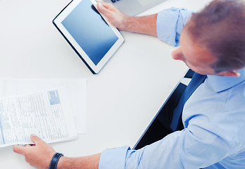 Image showing businessman with tablet pc and papers in office