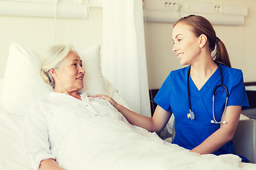 Image showing doctor or nurse visiting senior woman at hospital