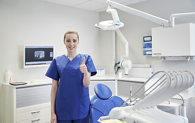 Image showing happy female dentist showing thumbs up at clinic