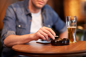 Image showing man drinking beer and smoking cigarette at bar