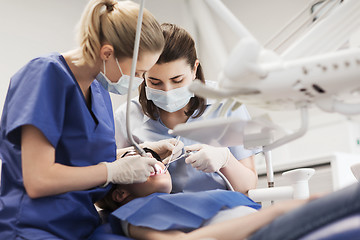 Image showing female dentists treating patient girl teeth