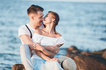 Image showing Happy young romantic couple relaxing on the beach and watching the sunset