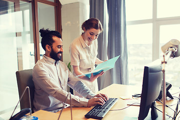 Image showing happy creative team with computer in office