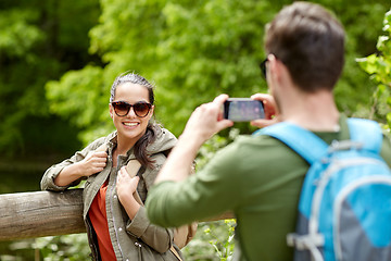 Image showing couple with backpacks taking picture by smartphone